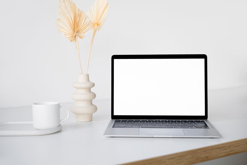 Low-maintenance digital products — Stylish minimalist workspace featuring a laptop, vase with decorative plants, and a mug