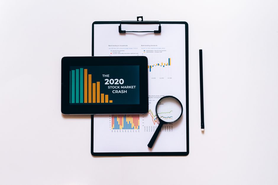 Profitable paid newsletter — Tablet, magnifying glass, and clipboard for stock market analysis.