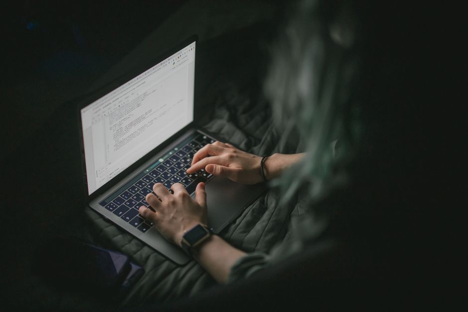 Shopify vs woocommerce review — Close-up of hands typing on a laptop with code on screen, perfect for work from home and